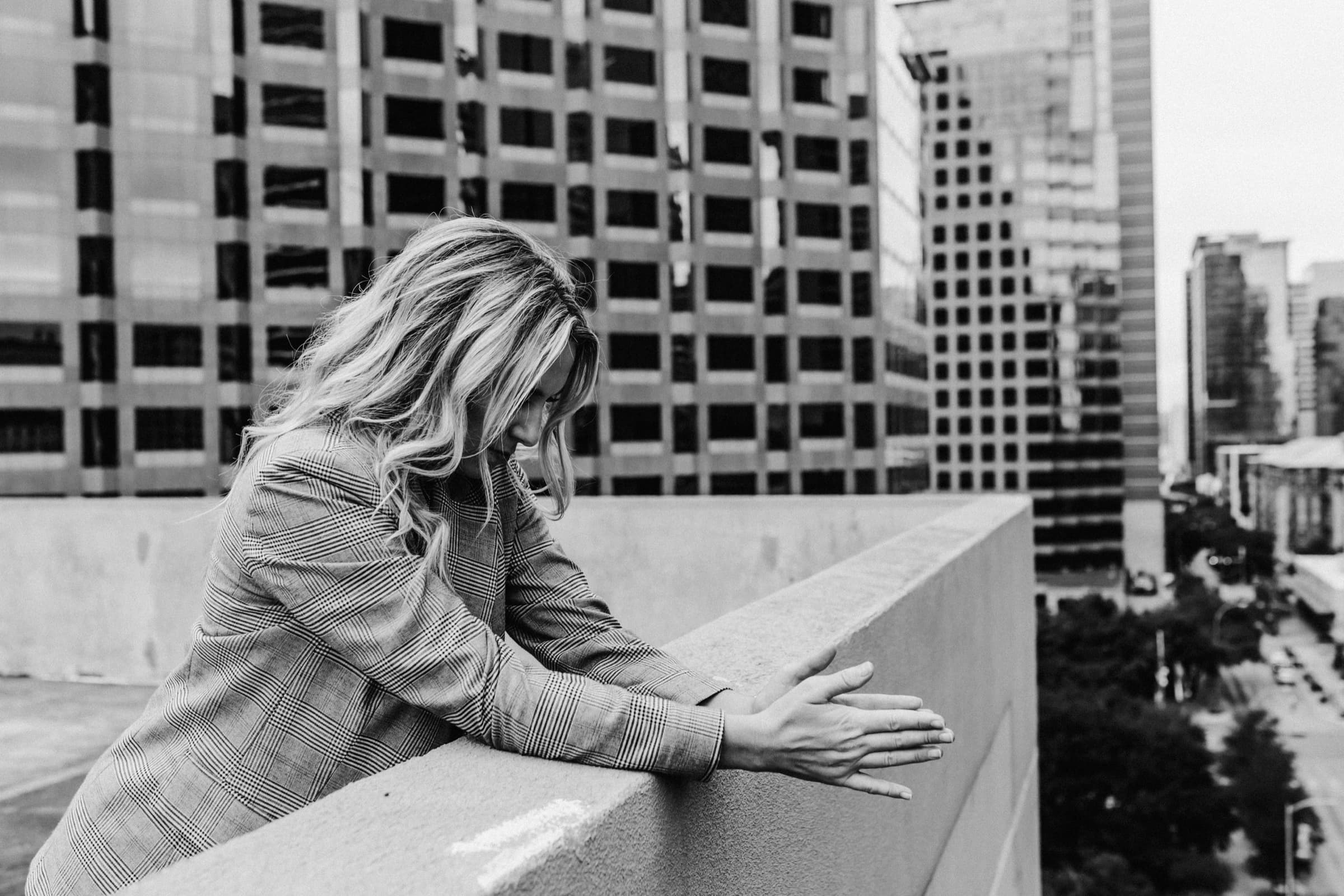 Brittany Moore leaning on a rooftop ledge above downtown Austin